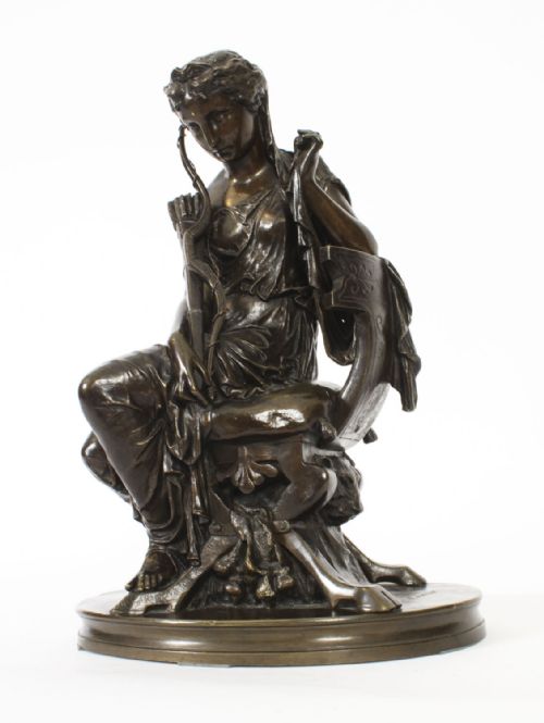 fig 6. A 19th-century dark patinated bronze sculpture depicting the classical goddess Diana seated on a chair with a bow and quiver, set upon an oval base.