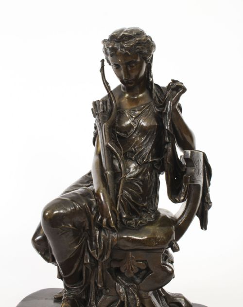 fig 8. A 19th-century dark patinated bronze sculpture depicting the classical goddess Diana seated on a chair with a bow and quiver, set upon an oval base.