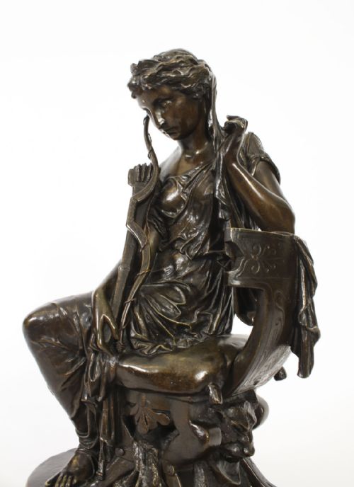fig 10. A 19th-century dark patinated bronze sculpture depicting the classical goddess Diana seated on a chair with a bow and quiver, set upon an oval base.