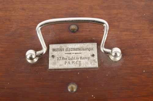 fig 2. A pair of open mahogany boxes containing early 20th-century French electrotherapy devices with brass switches and a green wire coil.