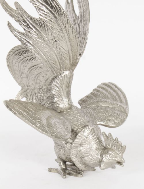 fig 3. A pair of silver-plated fighting cockerels facing each other in dynamic poses with detailed plumage.