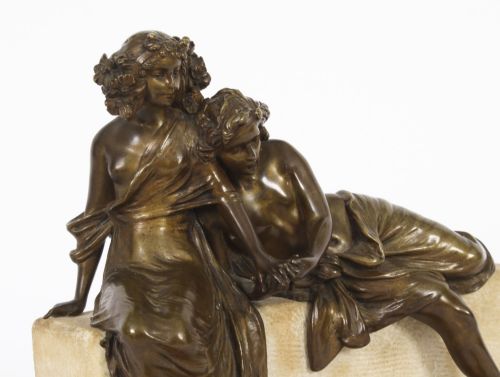 fig 2. A dark bronze sculpture depicting two classical draped figures resting on a light-coloured carved marble bench base.