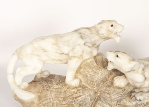 fig 2. An Art Deco carved alabaster sculpture depicting two snarling lionesses positioned atop a rough-hewn stone base.