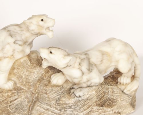 fig 3. An Art Deco carved alabaster sculpture depicting two snarling lionesses positioned atop a rough-hewn stone base.