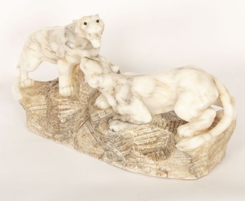 fig 4. An Art Deco carved alabaster sculpture depicting two snarling lionesses positioned atop a rough-hewn stone base.