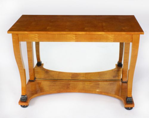 fig 1. A 19th-century Biedermeier console table featuring figured maserbirch veneer, a mirrored back panel, curved front legs with ebonised feet, and a concave lower shelf.