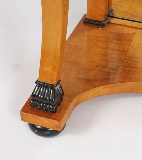 fig 4. A 19th-century Biedermeier console table featuring figured maserbirch veneer, a mirrored back panel, curved front legs with ebonised feet, and a concave lower shelf.