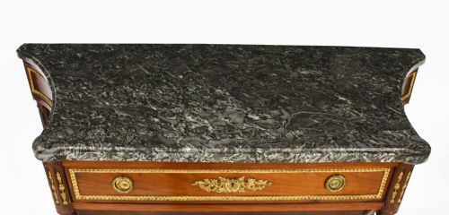 fig 2. An antique French Louis XVI Revival mahogany console table featuring a grey marble top, gilt-bronze mounts, fluted tapered legs, and a lower tier shelf.
