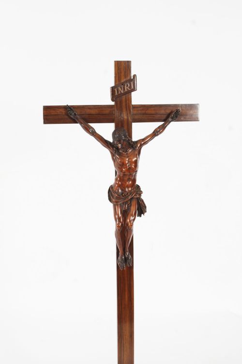 fig 1. A carved wooden Corpus Christi mounted on a dark olive wood cross with an INRI scroll, supported by a tiered hexagonal wooden base.