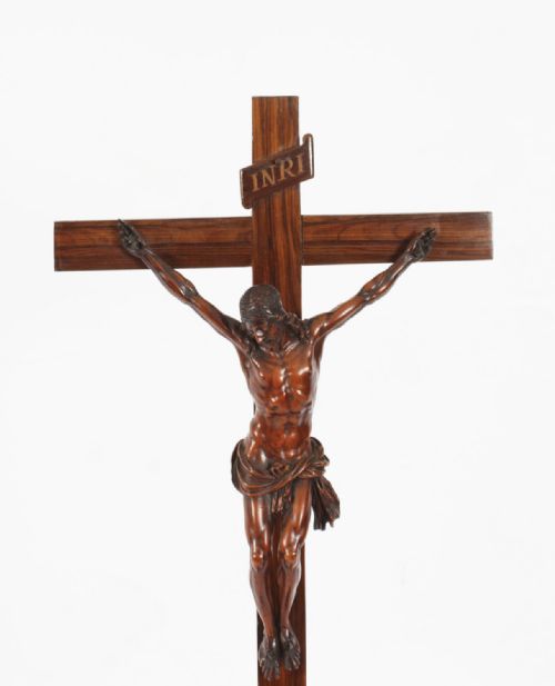 fig 3. A carved wooden Corpus Christi mounted on a dark olive wood cross with an INRI scroll, supported by a tiered hexagonal wooden base.