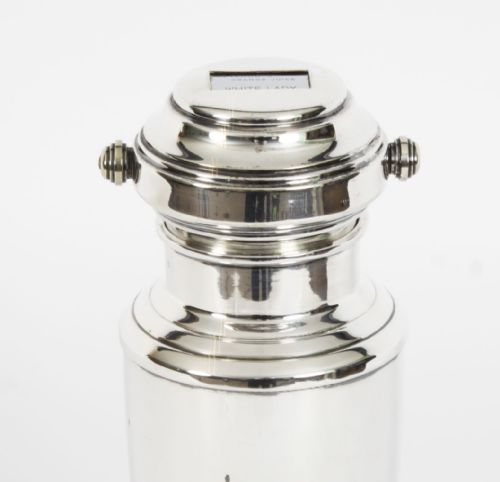 fig 2. An Art Deco silver plated cocktail shaker featuring an engraved monogram letter D and a top section with a recipe viewing window.