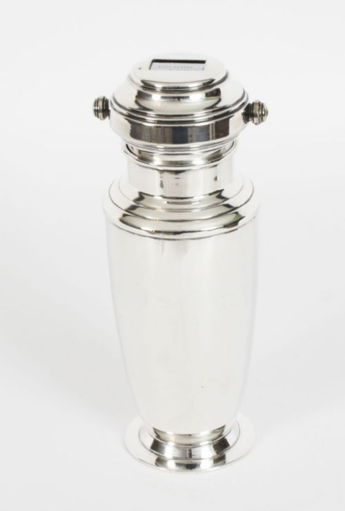 fig 5. An Art Deco silver plated cocktail shaker featuring an engraved monogram letter D and a top section with a recipe viewing window.
