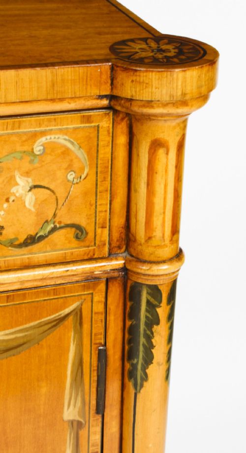 fig 6. A pair of 19th-century Adam Revival satinwood side cabinets featuring hand-painted classical swags, musical trophies, and slender turned legs.