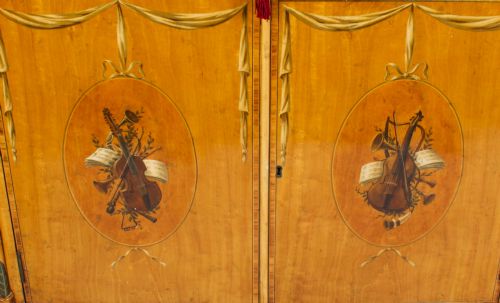 fig 7. A pair of 19th-century Adam Revival satinwood side cabinets featuring hand-painted classical swags, musical trophies, and slender turned legs.