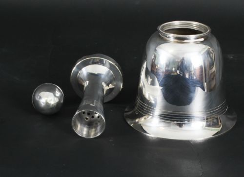 fig 2. A silver-plated Art Deco cocktail shaker shaped like a handbell with a polished metal finish.