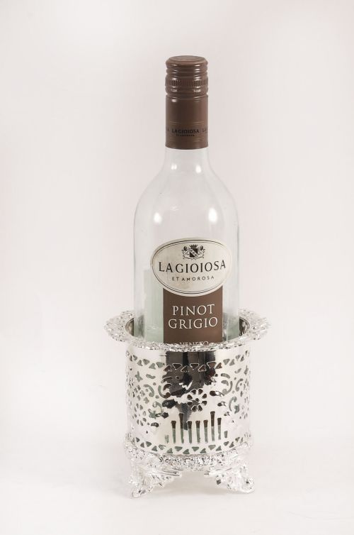 fig 1. A cylindrical silver-plated container featuring intricate pierced scrollwork patterns, a flared rim, and four detailed cast feet.