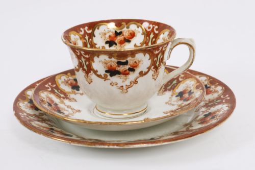 fig 1. An antique twenty-one piece bone china tea set featuring white porcelain decorated with elaborate brown and gilded floral border patterns.