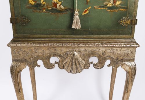 fig 6. A green lacquered two-door cocktail cabinet with hand-painted chinoiserie scenes resting on a carved silver gilt stand with cabriole legs.