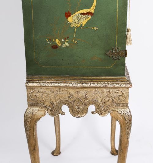 fig 7. A green lacquered two-door cocktail cabinet with hand-painted chinoiserie scenes resting on a carved silver gilt stand with cabriole legs.