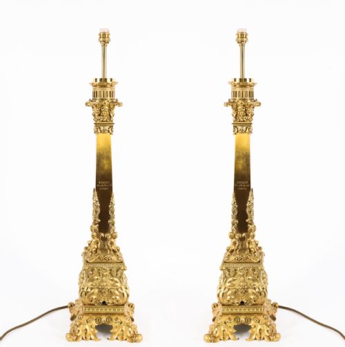 fig 1. A pair of 19th-century French ormolu table lamps featuring cast gilt bronze bases and cream flared fabric shades with tassel fringe trim.
