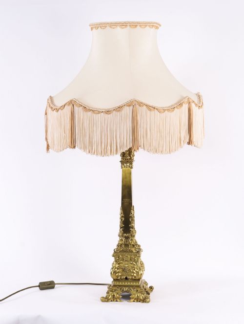 fig 3. A pair of 19th-century French ormolu table lamps featuring cast gilt bronze bases and cream flared fabric shades with tassel fringe trim.