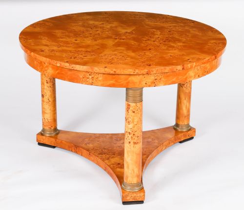 fig 9. A circular 20th-century Biedermeier revival coffee table made from burr elm with three column legs set on a triform plinth base.