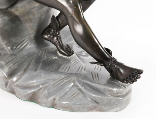 fig 5. A dark patinated bronze sculpture depicting a nude seated Hermes resting on a carved grey marble base.