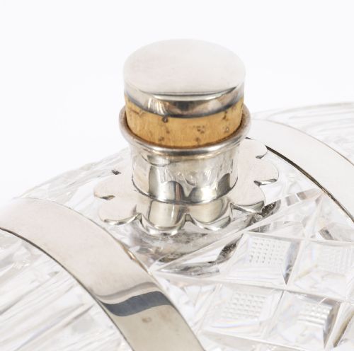 fig 2. A nineteenth-century cut crystal barrel decanter with silver-plated hoops, tap, and miniature bucket accessory resting on a four-legged silver stand.