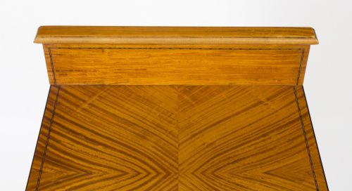 fig 1. A Victorian satinwood bedside cabinet featuring a bowfront shape, chevron veneer patterns, a single drawer, a cupboard door, and tapered square legs.