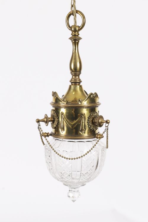 fig 2. An Edwardian ceiling pendant light featuring an ornate brass gallery decorated with swags and rosettes, suspending a cut crystal glass globe with a pointed base finial.