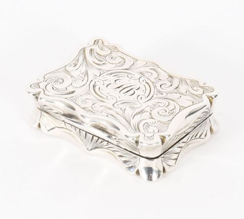 fig 1. An open Victorian sterling silver vinaigrette displaying a scalloped edge and a hinged floral pierced gilt interior grille.
