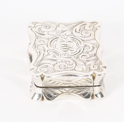 fig 2. An open Victorian sterling silver vinaigrette displaying a scalloped edge and a hinged floral pierced gilt interior grille.