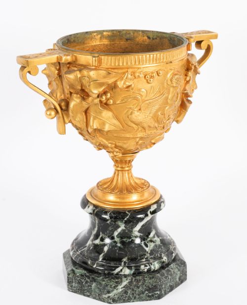 fig 4. A pair of nineteenth-century French gilt bronze classical urns featuring relief carvings and scroll handles, mounted on dark green marble bases.