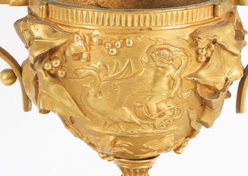 fig 7. A pair of nineteenth-century French gilt bronze classical urns featuring relief carvings and scroll handles, mounted on dark green marble bases.