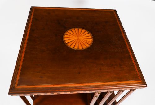 fig 5. An Edwardian flame mahogany revolving bookcase featuring two tiers, vertical slatted sides with brass studs, satinwood inlay, and castors.