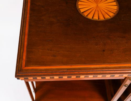 fig 6. An Edwardian flame mahogany revolving bookcase featuring two tiers, vertical slatted sides with brass studs, satinwood inlay, and castors.