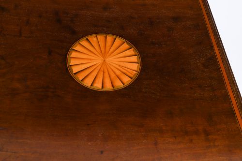 fig 7. An Edwardian flame mahogany revolving bookcase featuring two tiers, vertical slatted sides with brass studs, satinwood inlay, and castors.