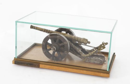 fig 1. A nineteenth-century scale model of a fortress culverin cannon with a cast bronze barrel mounted on a dark wooden carriage with iron fittings and a timber base.