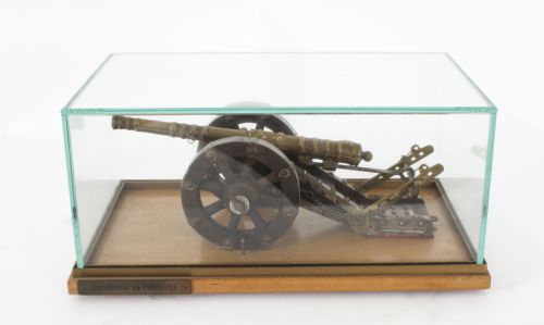 fig 2. A nineteenth-century scale model of a fortress culverin cannon with a cast bronze barrel mounted on a dark wooden carriage with iron fittings and a timber base.