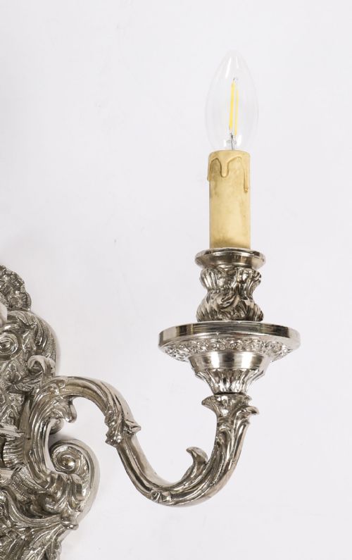 fig 3. A pair of ornate silver-plated French wall sconces with three scrolling candle arms and detailed acanthus leaf decoration.