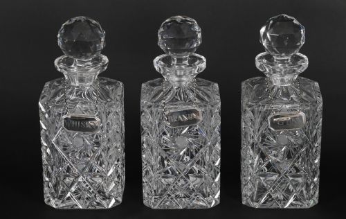 fig 6. An Edwardian Betjemanns coromandel wood tantalus with hallmarked silver mounts holding three cut-crystal decanters.