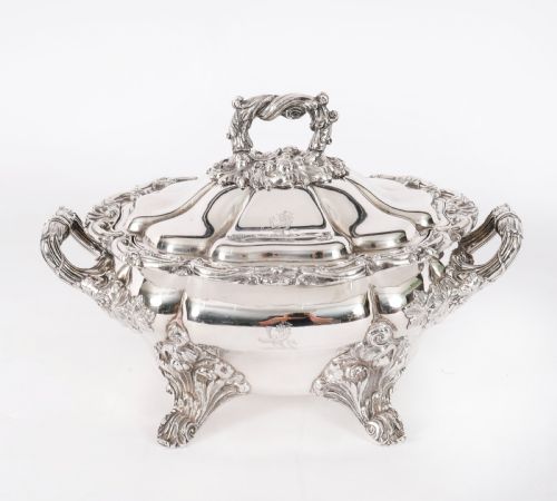 fig 2. A pair of silver-plated oval sauce tureens featuring domed lids, foliate scroll handles, and decorative carved feet.