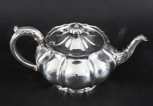 fig 2. A Georgian sterling silver teapot featuring a lobed melon-shaped body, leaf-engraved spout, and insulated handle.