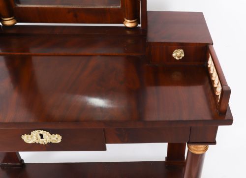 fig 4. A 19th-century French Empire mahogany dressing table with a central adjustable mirror, gilded column supports, small side drawers, and a lower curved stretcher.