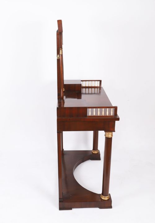 fig 5. A 19th-century French Empire mahogany dressing table with a central adjustable mirror, gilded column supports, small side drawers, and a lower curved stretcher.