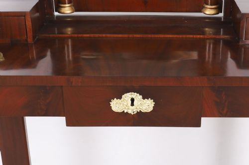fig 3. A 19th-century French Empire mahogany dressing table with a central adjustable mirror, gilded column supports, small side drawers, and a lower curved stretcher.