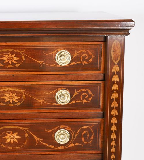 fig 2. An Edwardian mahogany Wellington chest featuring eight inlaid drawers, satinwood floral motifs, a right-side locking stile, and brass handles.