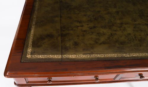 fig 2. A nineteenth-century Victorian mahogany partners writing desk featuring a green leather inset top, frieze drawers with turned wood knob handles, and tapered legs on brass castors.