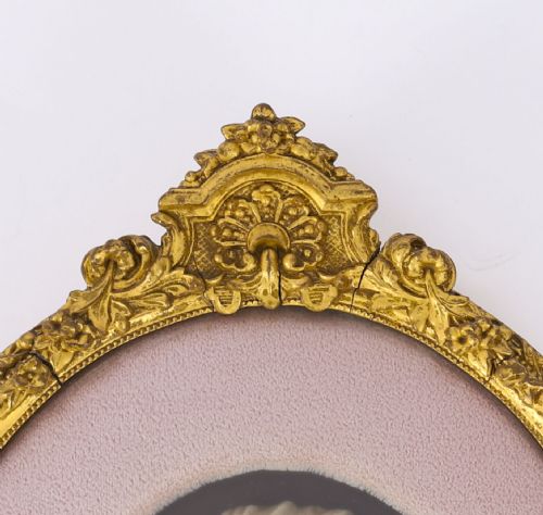 fig 3. A pair of oval gilt-framed 19th-century wax portrait reliefs featuring male and female profile busts set against dark backgrounds with pink fabric mounts.