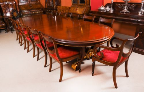 fig 2. A large, polished mahogany extending dining table supported by two carved twin pedestals with parcel-gilt detailing.